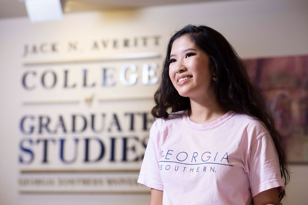 Georgia Southern student poses in front of Averitt College of Graduate Studies.