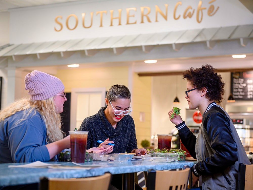 Three students eating at the dining commons of the Armstrong campus of Georgia Southern University.