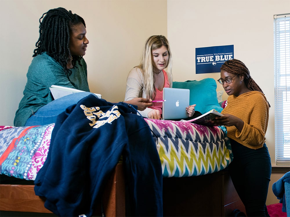 Three students studying together in a dorm room at the Armstrong campus of Georgia Southern University.