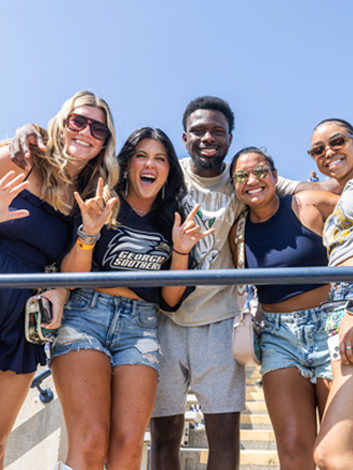 Five students pose with excitement after arriving to the stadium for a Georgia Southern sporting event or rally.