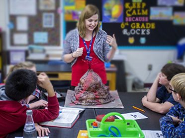 A student teacher from Georgia Southern's Department of Middle Grades and Secondary Education explains how volcanoes work to a classroom of students