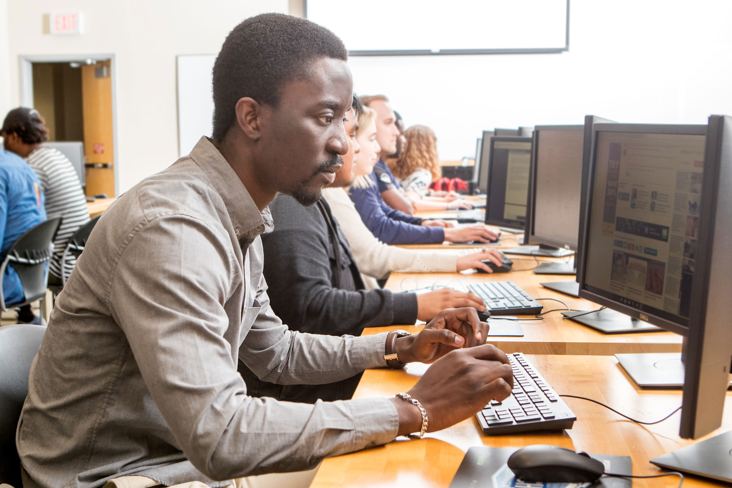 Georgia Southern students in computer lab, Student focusing on computer programming