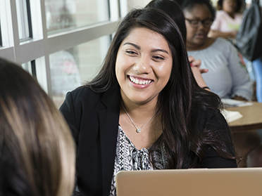 Georgia Southern student in business apparel, smiling and speaking to someone across a table.