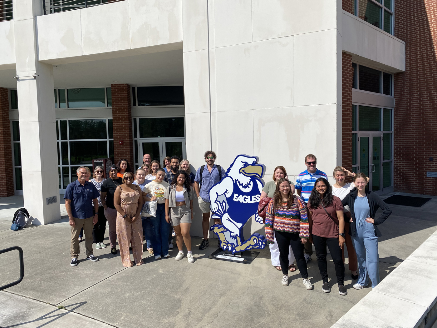 A group of participants for the NOAA professional development session for Adaptive Planning for Coastal Communities by a statue of the Georgia Southern Eagle.