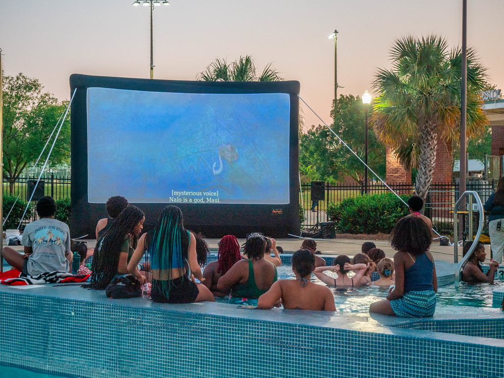 A group of Georgia Southern students watch a move in a swimming pool together at the CRI RAC poolside premier.