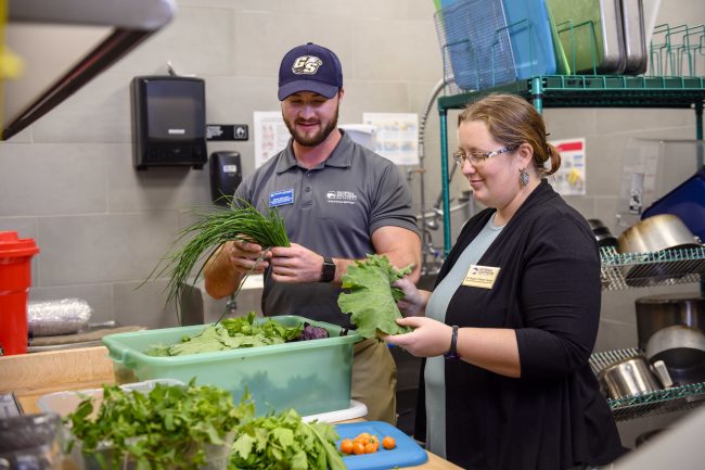 Ryan Brzycki, Assistant Director of Eagle Dining services and SARC curator Brigette Brinton sort through produce to be used at the Southern Cafe on the Georgia Southern University Armstrong Campus.