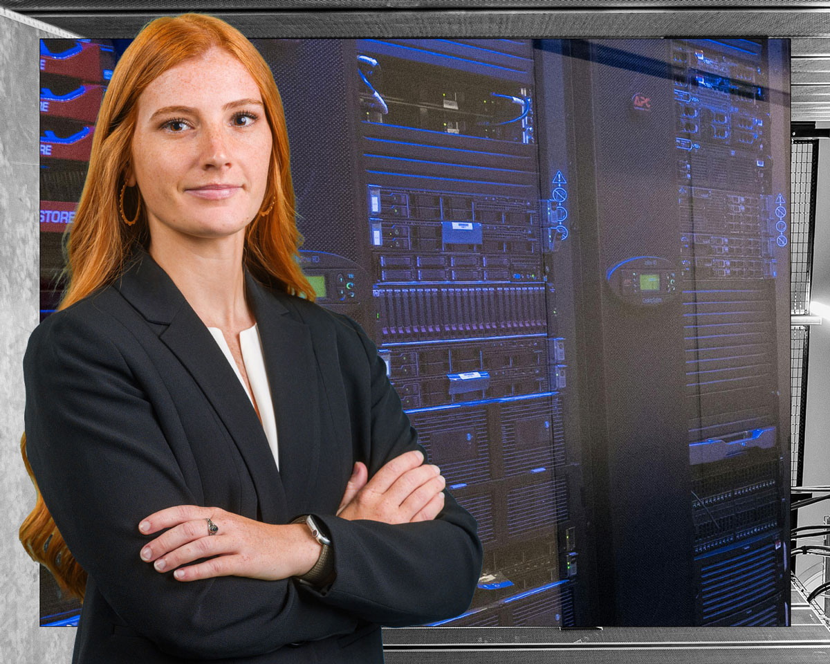 Young business woman standing in front of data servers.